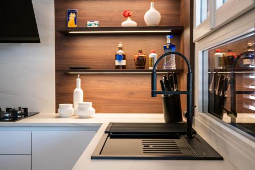 1. Cucina con ante laccate bianco opaco e pareti boiserie in noce canaletto-min