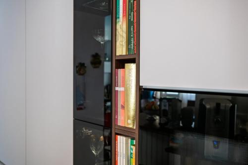 14. Cucina con ante laccate bianco opaco e pareti boiserie in noce canaletto-min