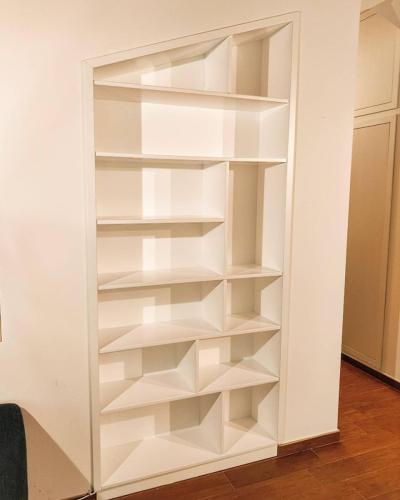 Libreria laccata bianco opaco realizzata all'interno di una nicchia