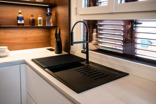 6. Cucina con ante laccate bianco opaco e pareti boiserie in noce canaletto-min
