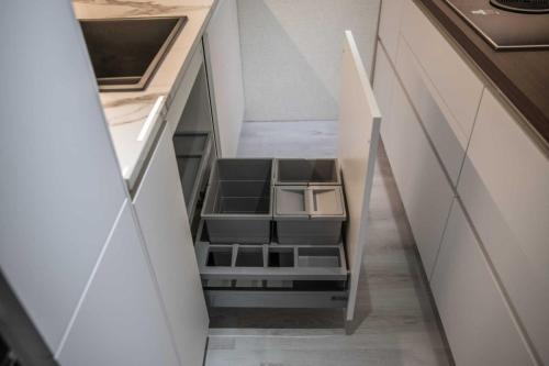 6. Cucina laccata effetto fenix bianco opaco con top e boiserie colore noce canaletto e mensole in legno di ulivo-min