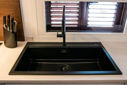 7. Cucina con ante laccate bianco opaco e pareti boiserie in noce canaletto-min